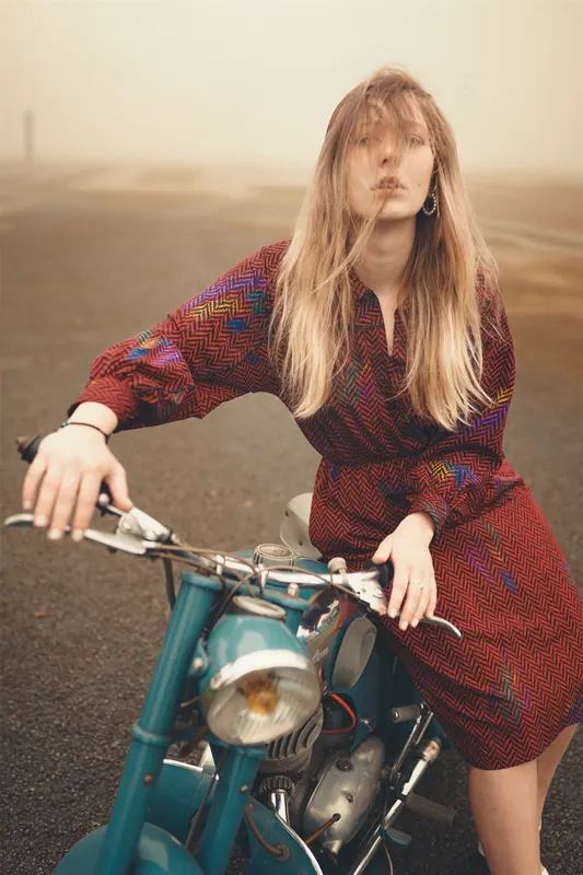 Kessy assise sur une moto ancienne