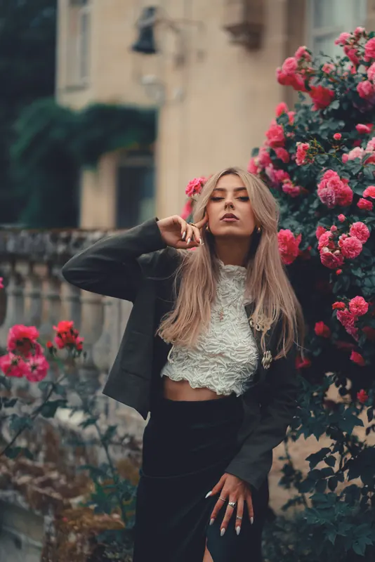 Anaïs en haut blanc en dentelle devant le rosier grimpant de la maison