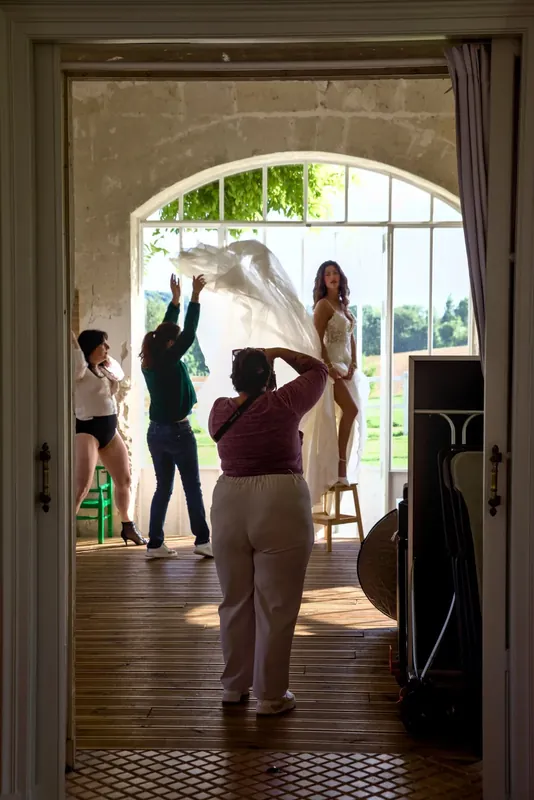 Shooting dans l’enfilade des pièces, la porte vitrée grande ouverte sur le parc