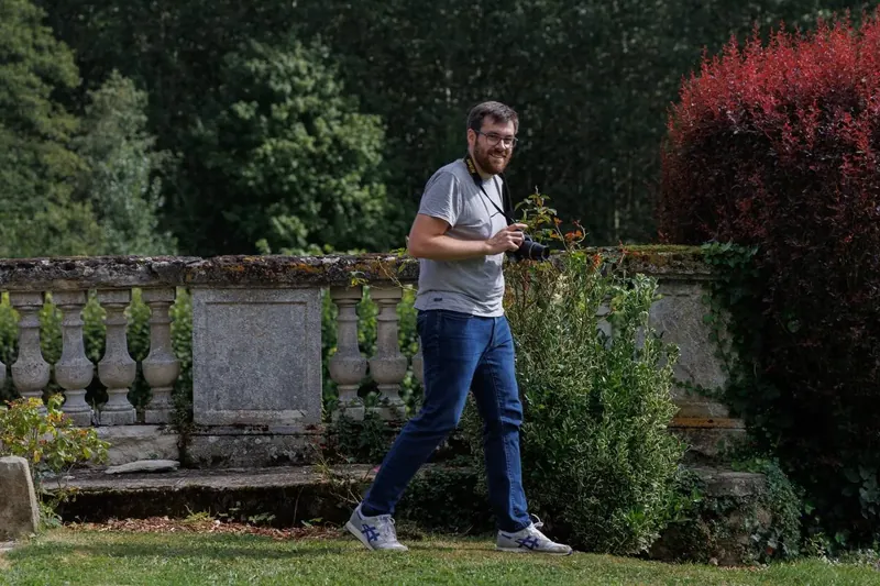 Un photographe traverse la terrasse, appareil à la main