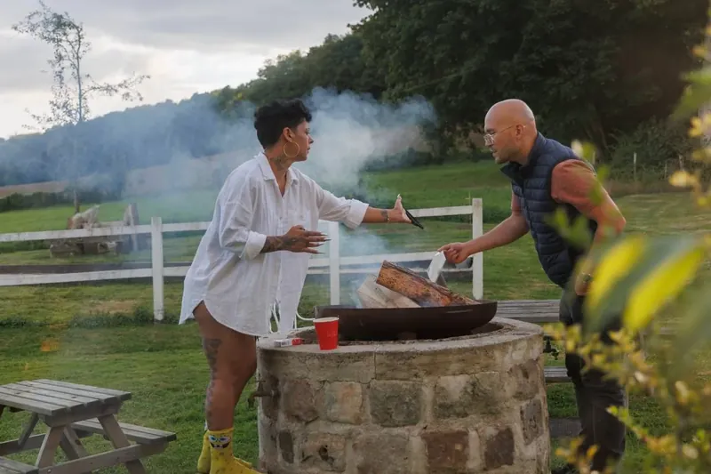 Le barbecue s’allume dans le parc avant le repas du soir