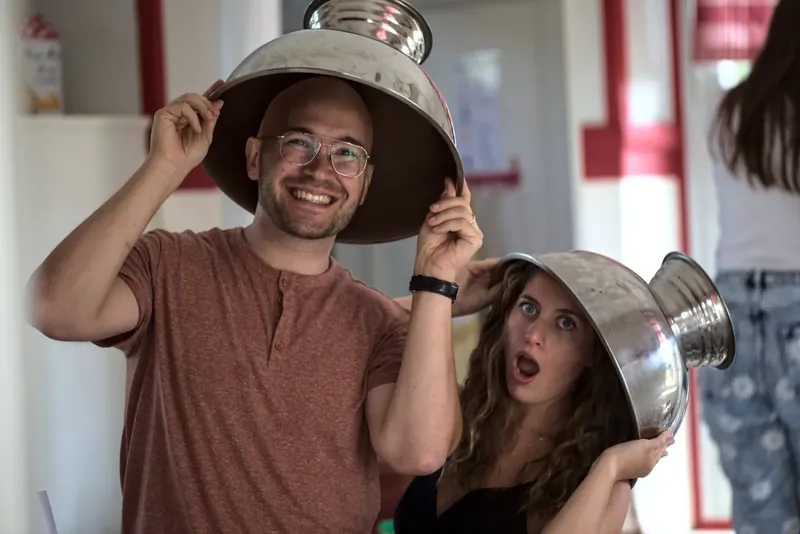 Fous rires en cuisine, une passoire en guise de chapeau